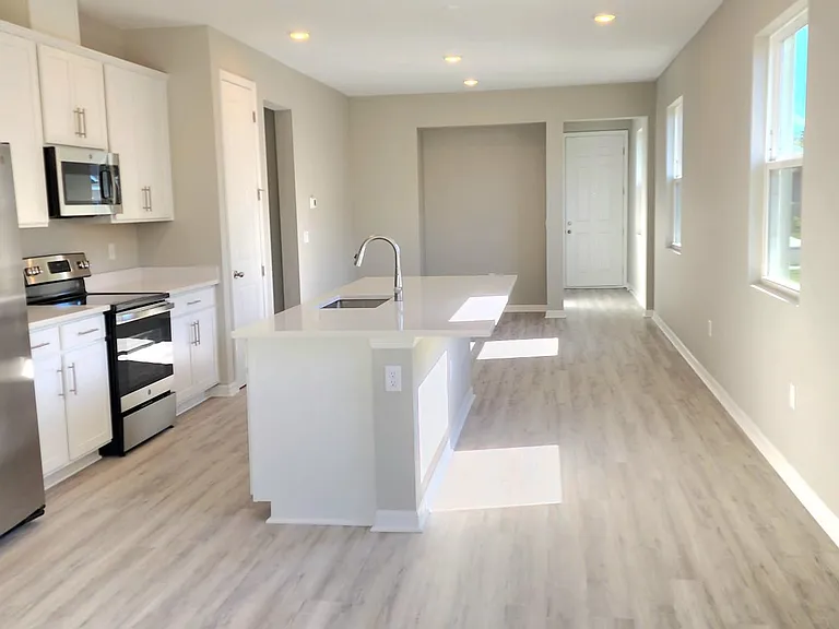 The kitchen seamlessly flows into the separate dining area and great room, which offers access to the covered lanai with a screen enclosure.