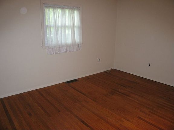 Three neutral bedrooms with hardwood flooring