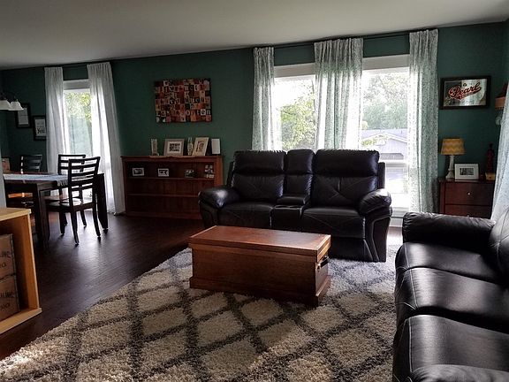 Open concept living room/ dining with new engineered wood flooring and lots of natural light