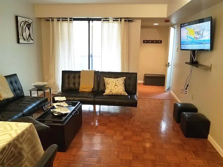 View of the living room, facing towards the front balcony. The apartment entrance is on the right.
