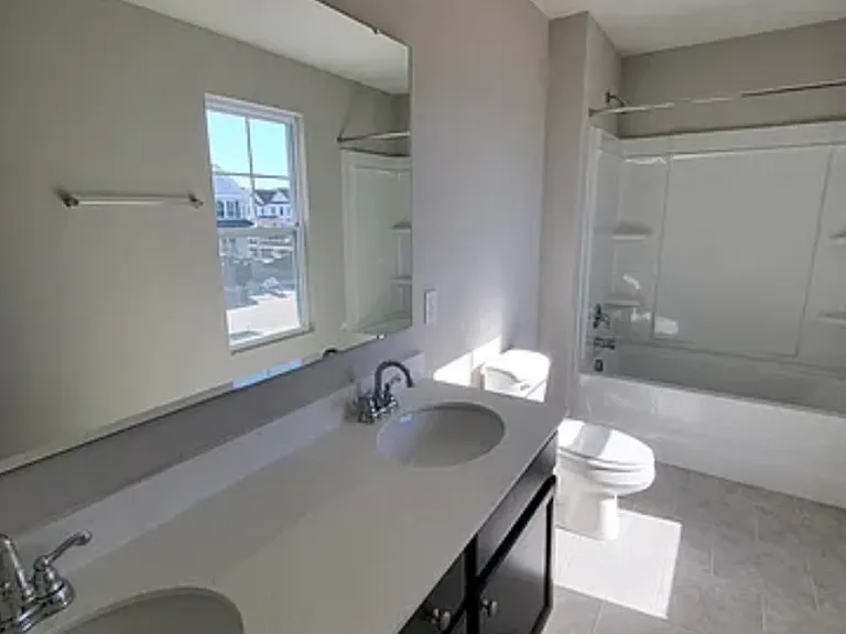 Secondary bathroom with dual vanities & tub