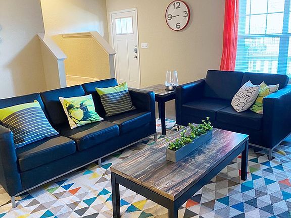 Relax in your oversized living room featuring a ceiling fan.