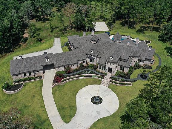 Aerial of cleared area of acreage. 2 stocked ponds on property. 6 car climate controlled garages plus climate controlled upstairs storage above garages! Well for irrigation - new in 2019! Half court sports court! All located on heavily wooded Cul de 