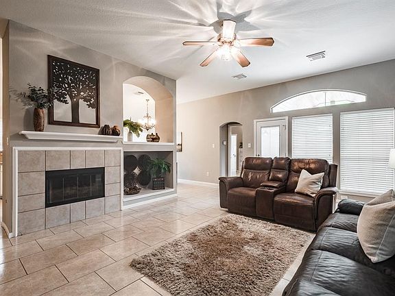 This cozy family room is centered by the fireplace and connects to the kitchen with access to covered patio and pool.