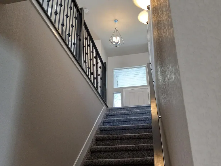 Looking up the stairs from Rec Room, notice the large window over the front-door