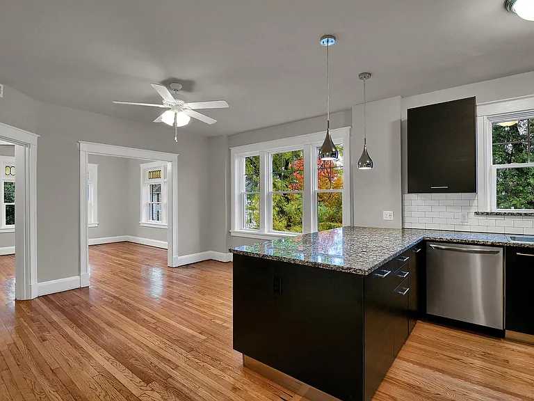 Looking from the kitchen through the dining room into the family room: granite bartop peninsula. Teardrop pendants.