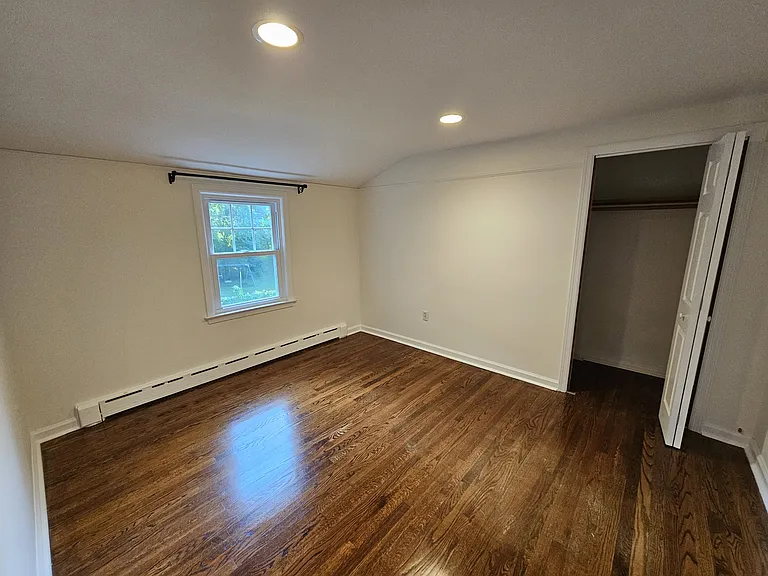 1st Floor Bedroom 4 _ View 1
Bedroom with hardwood floors, recessed lighting, natural light, and a storage closet with a large shelf and hanging rod.