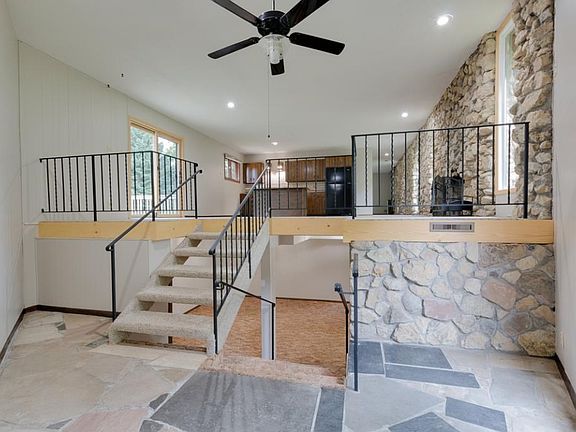 From the moment you enter you'll know you've arrived somewhere special! The limestone flooring in the vaulted entryway is in beautiful condition! Iron rails and plank staircase offers an open view throughout the home!