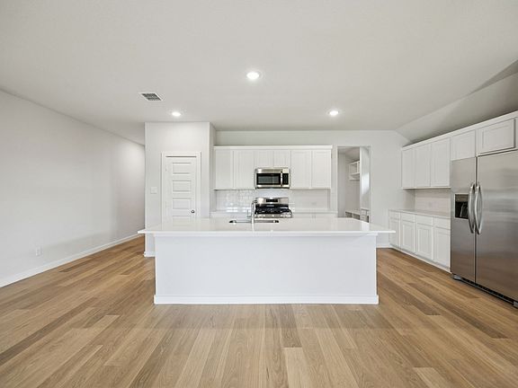 Kitchen in the Heisman home plan by Trophy Signature Homes - REPRESENTATIVE PHOTO