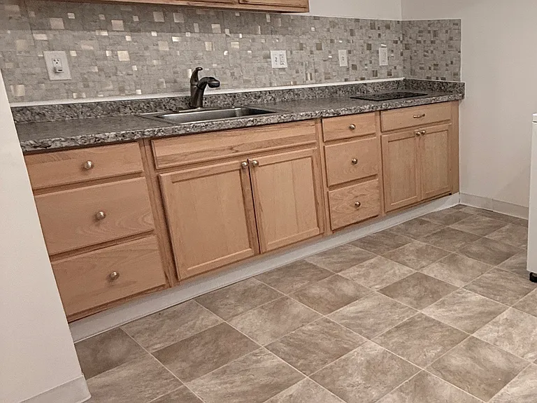 New kitchen with cooktop, microwave and fridge. Recessed light above cooktop with dimmer.