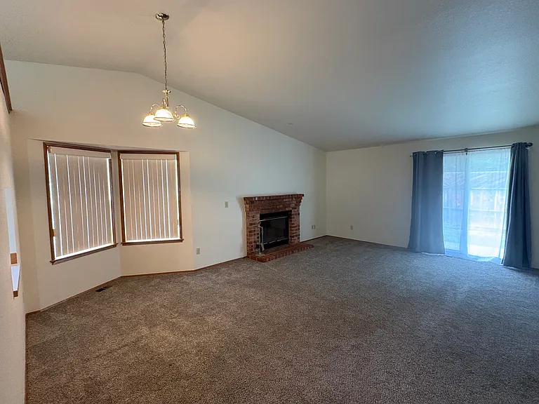 Living room with fireplace, and sliders to the back patio.