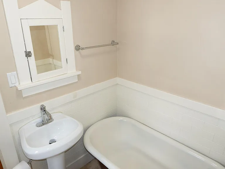 The main bathroom has a pedestal sink and clawfoot tub with shower.