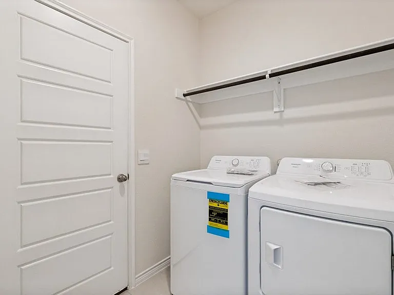 Dedicated laundry area featuring a shelf and hanging rod for organization