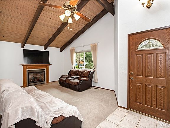 Front Door and Living Area with a Gas Fireplace and Vaulted Ceiling