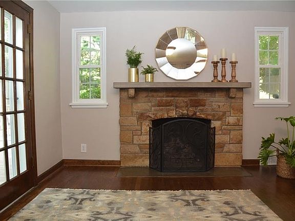 Stone fireplace is accented by charming windows on each side. Additional glass door brings so much more natural sunlight into th