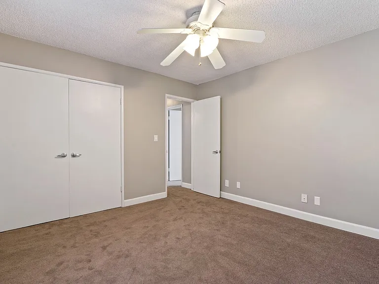 Bedroom with carpet flooring, double door closet, ceiling fan