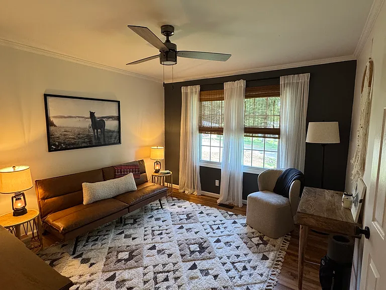 Third bedroom/home office space; full size faux leather futon, plush rug, desk, desk chair, dresser, standard closet.
