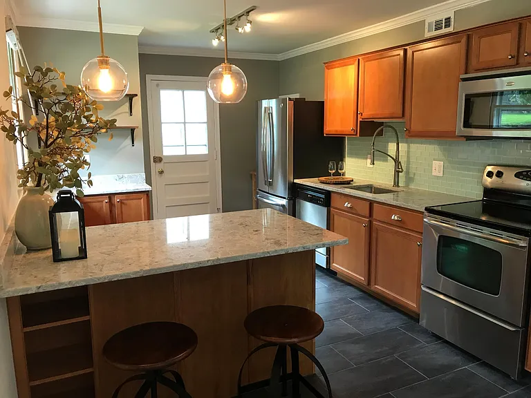 Lots of quartz countertop space and a peninsula for casual d