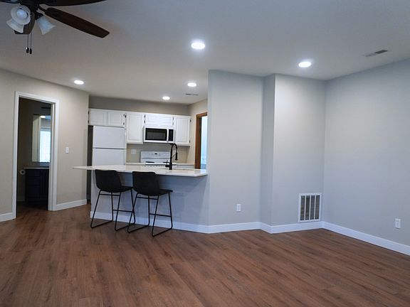 Spacious living room with easy access to the outdoor screened-in porch on the first level_perfect for relaxation! The bartop seating area includes 2 barstools provided for tenants.