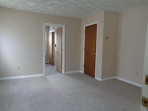 Living Room with wall to wall carpet, 2 windows, a coat closet. Newer paint throughout unit.