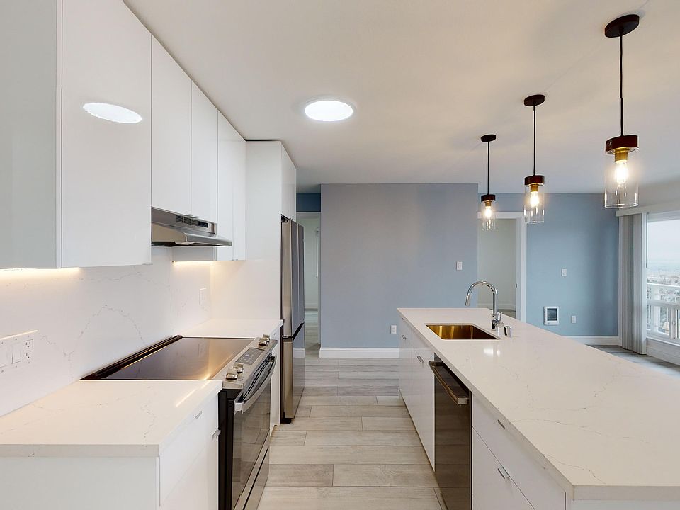 Kitchen with multiple cabinets, refrigerator, stove, range hood, and sink