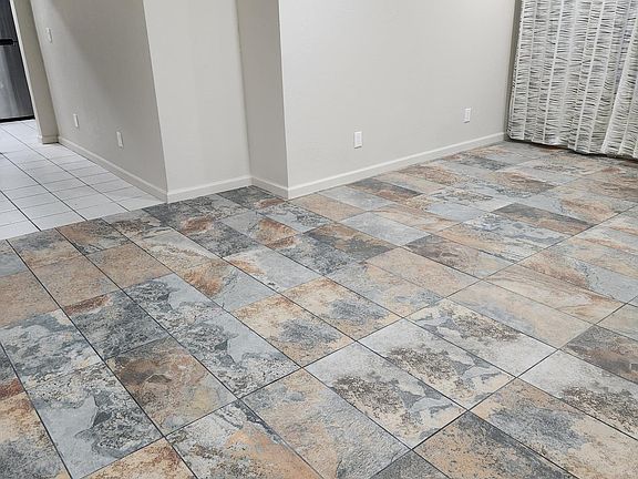 spacious living room has enough area for seating as well as a WFH area near large windows.