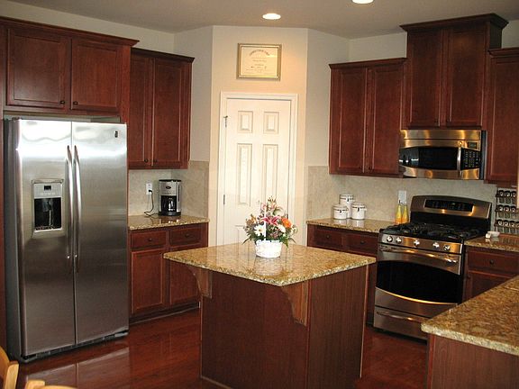 Gleaming kitchen with hardwoods, granite counters & island, SS appliances