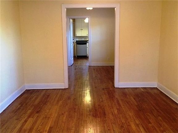 Living area, dining area, and kitchen at back.  Note the beautiful hardwood floors.
