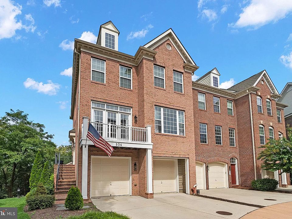 Street facing side of Townhome showing two-car garage and additional parking.