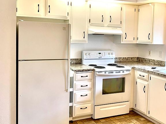 Kitchen with numerous cabinets and eating area.