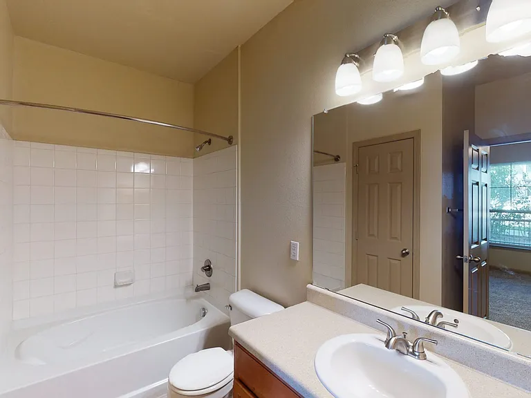 Apartment bathroom with wood-style flooring.