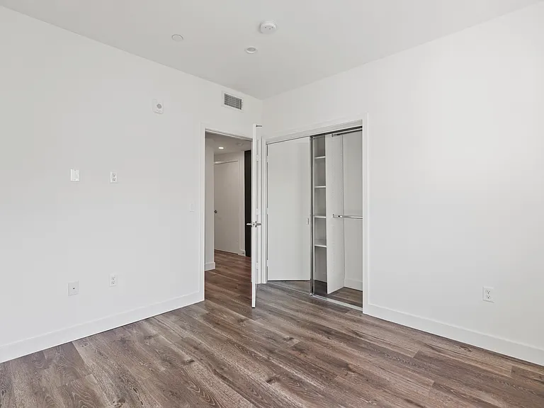 Bedroom with Mirrored Closet and Vinyl Flooring