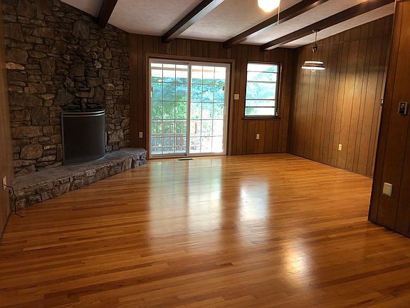 Living room/dining area with stone fireplace.