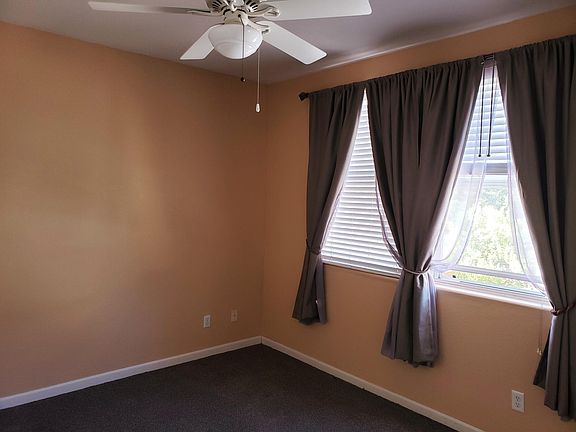 bedroom with new drapes, ceiling fan, and added sound insulation in walls for quiet.