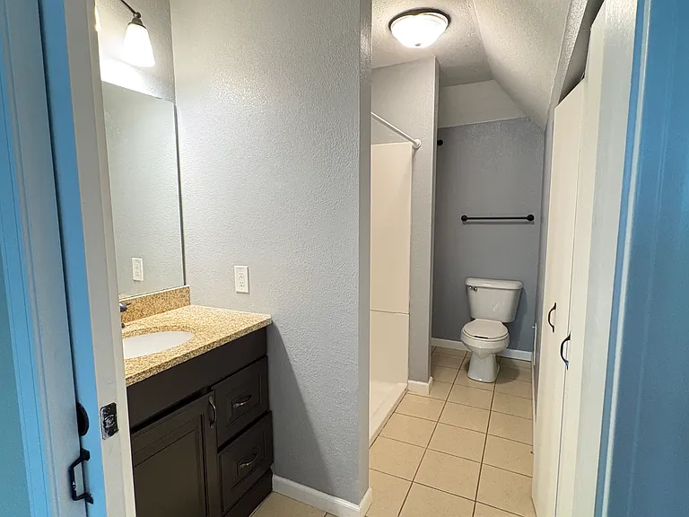 An additional linen closet tucked at the back of the bathroom provides ample storage for towels, linens, and everyday essentials.