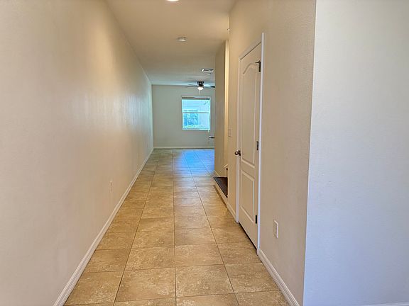 View from the entry way with a door to the garage to the right (not pictured), followed by a 1st floor bathroom, staircase and the living space and kitchen