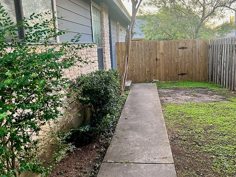 Walkway to the front door and fenced in yard.