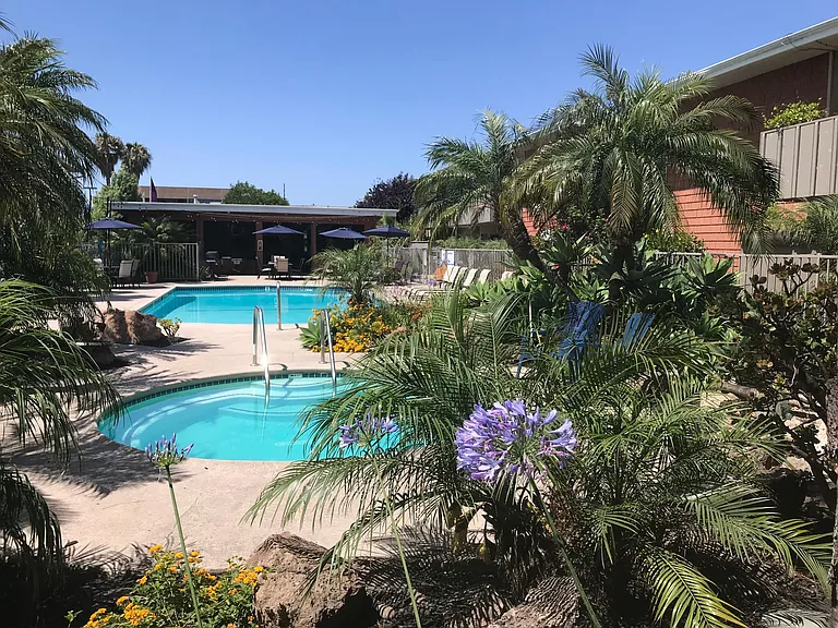Standing at spa area looking toward pool, club house, bbq area.