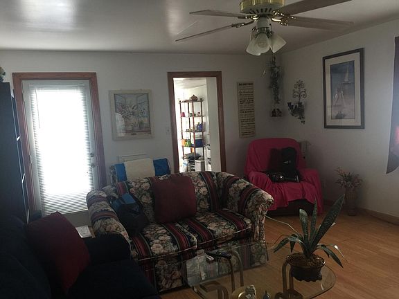 sitting area with kitchen entrance where shelving unit is.