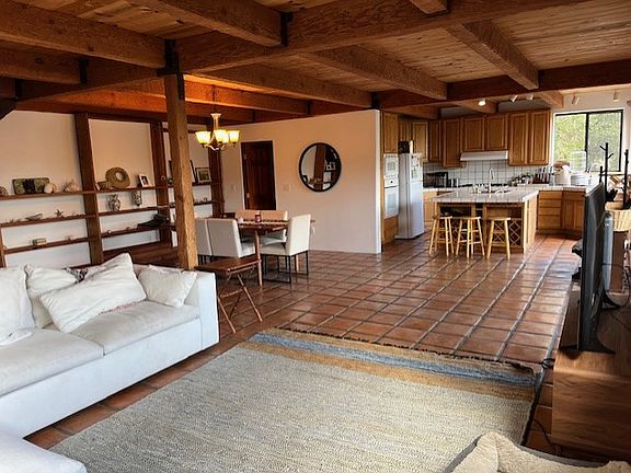 Living room, dining area, and open kitchen. Doorway on the left leads to the laundry area and a full bathroom.