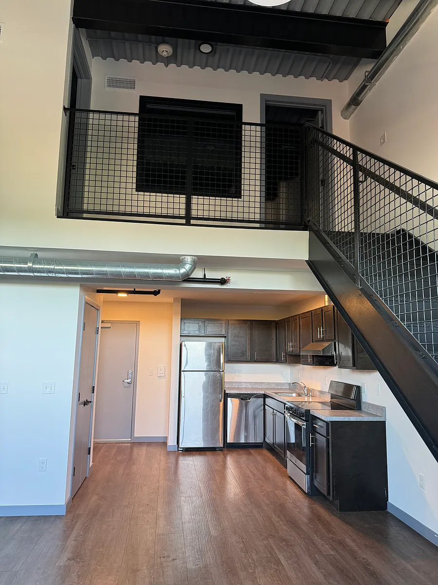 Kitchen area with Stainless Steel Appliances, open concept to living room area and stairs to the loft and bedroom - 15 S Bridge St #2