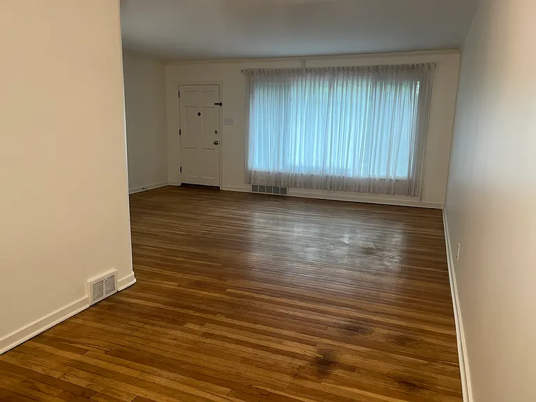 Main room with dining area (9' x 10') and living area (18' x 15'). Front door on left.