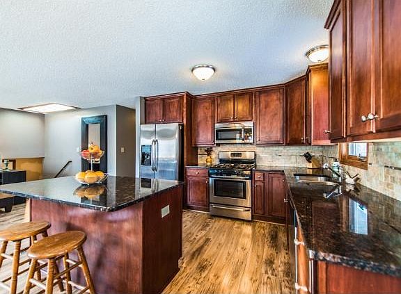 New Renovated Kitchen with Cherry Cabinets and Stainless Steel, Granite Countertops, Tiled Backsplash.