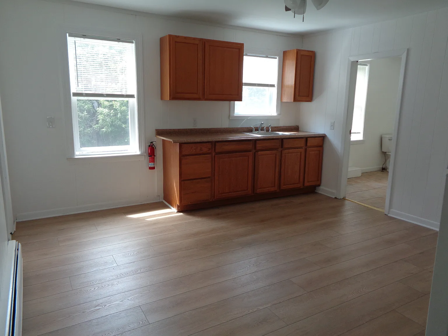 Bright Sunny Kitchen with New Flooring, New paint, New windows, New ceiling, New stove, New Refrigerator, New ceiling fan/light fixture, New window shades.