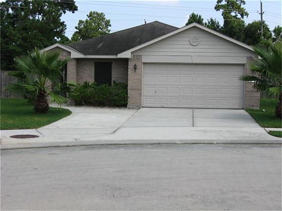 The current owner added an extra parking space making for a 3 car wide driveway. A couple of palm tr
