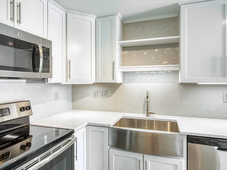 Tile backsplash, floating shelves, stainless steel appliances, apron sink, built-microwave...so much to love!