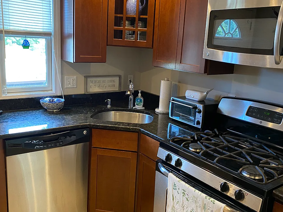 Stainless appliances including range (gas cooking), refrigerator, and microwave. Disposal also.