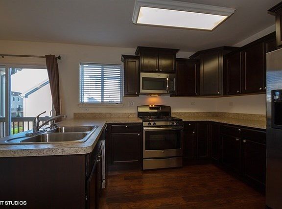 Upgraded kitchen cabinets, stainless steel appliances, and wood flooring