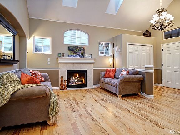 Notice the entrance chandelier, the GORGEOUS hickory wood floors that have just been professionally buffed and re-coated!  Impressive vaulted ceiling with skylights, gas fireplace, and arched alcove for flair!