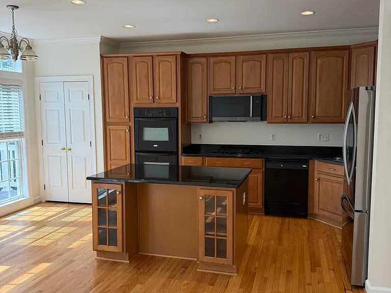 Kitchen with pantry to the left, new microwave and new LG fridge.
